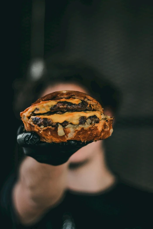 a close - up of someone's left hand holding a pastry