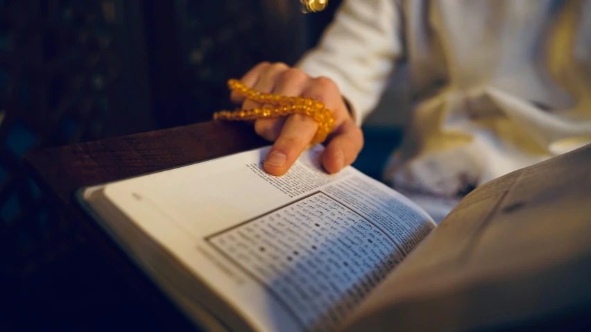 someone holding a book and praying in a church