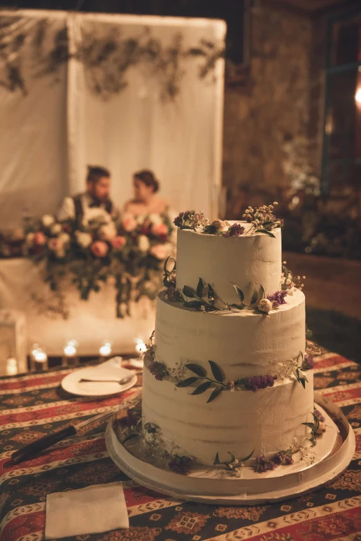 a wedding cake on display next to some candles