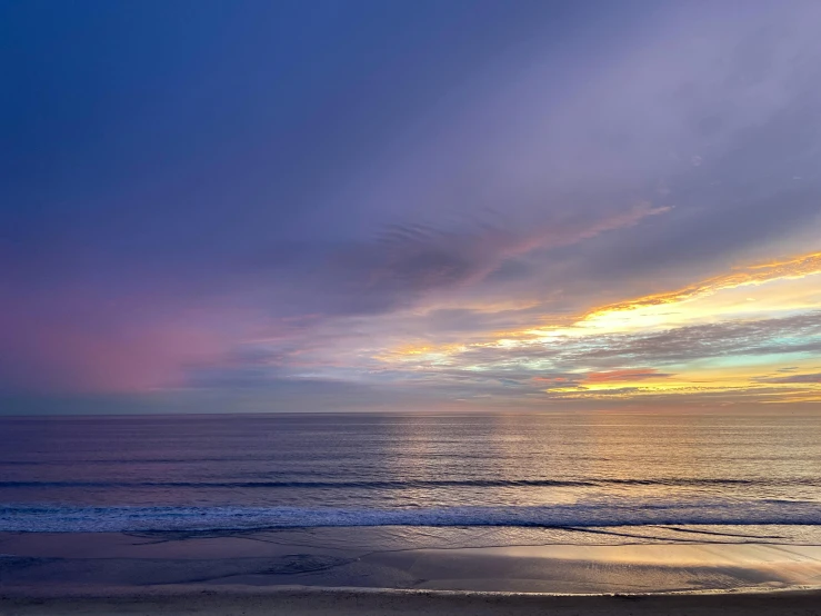 a man sitting on a beach next to the ocean