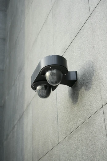 a close up of a surveillance camera on the side of a building