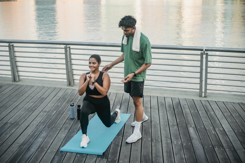 there are two people doing stretching exercises on the dock