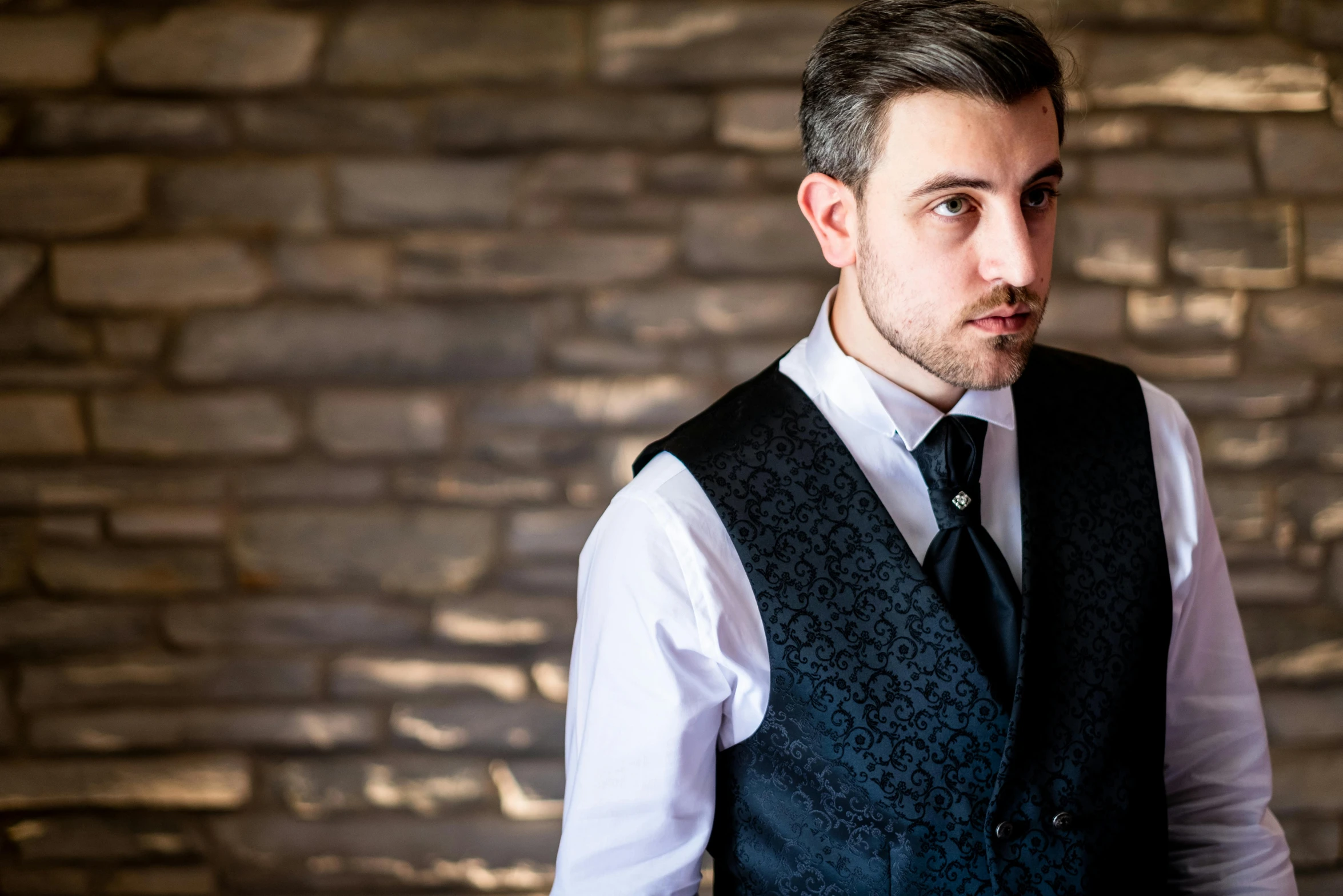 a man in a blue vest, white shirt and black tie