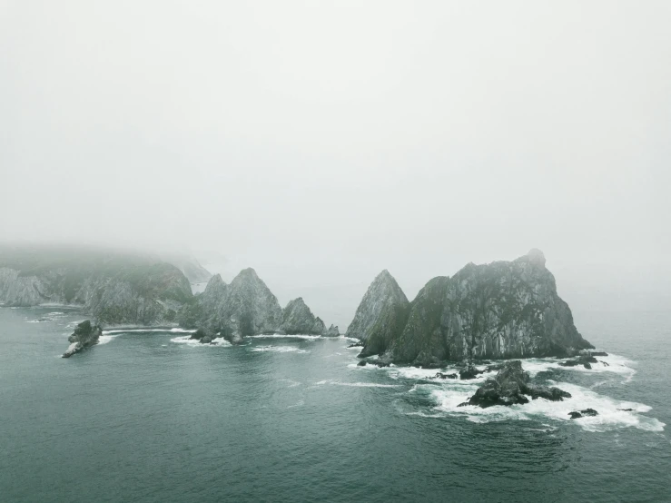 a boat sailing along the ocean in the fog