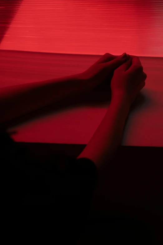 a person's hand holding a red piece of luggage in front of a red background