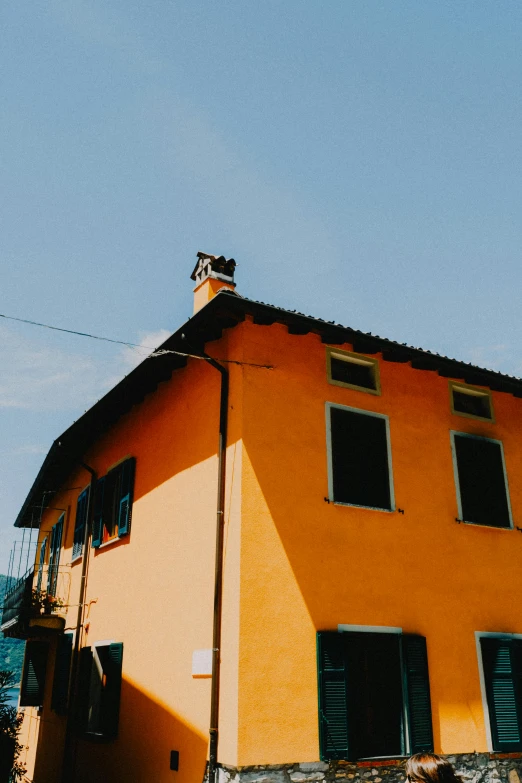 a tall yellow building with some black shutters