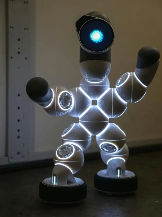 a robot with two lights on, next to it is the front end of its head and arm