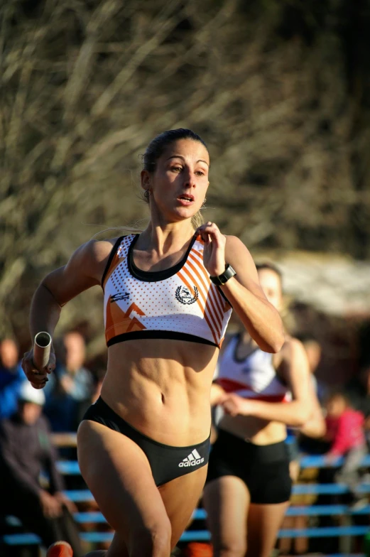 a woman running on a track while wearing a bikini