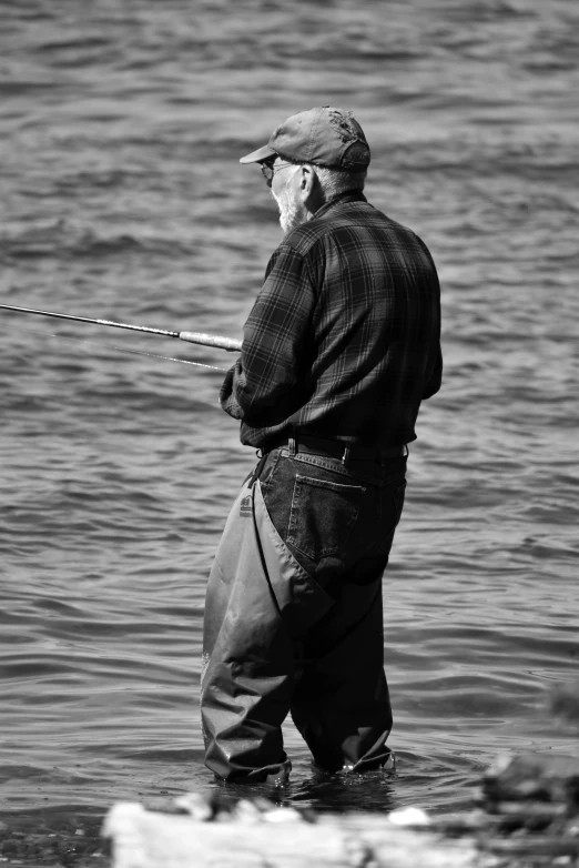 an elderly man with fishing poles standing in the water