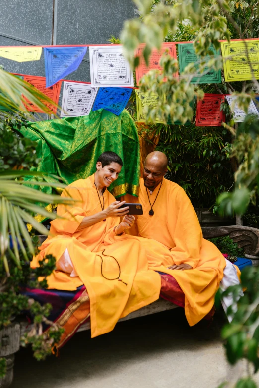 two monks are sitting outside on the bench