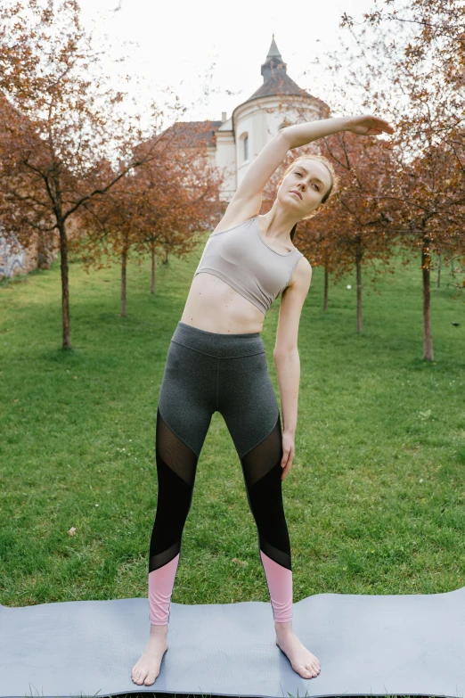 a woman is practicing her yoga outdoors