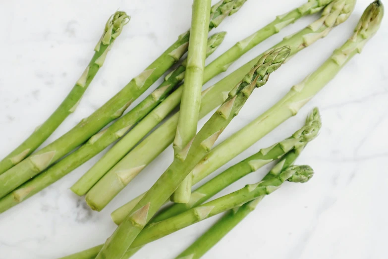 the stems of asparagus on a marble surface