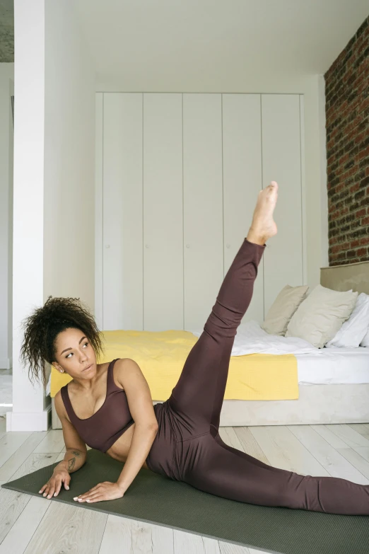 a woman lying on a yoga mat with her legs crossed