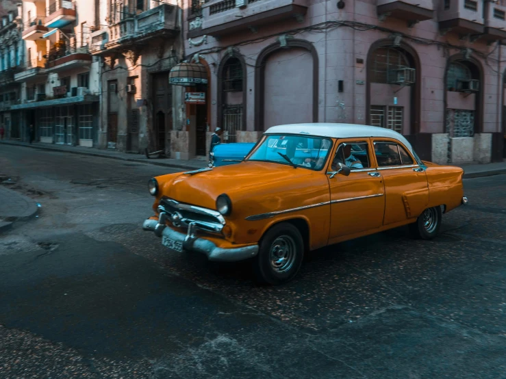 an old, rusted, classic car is parked on the side of the road in a city