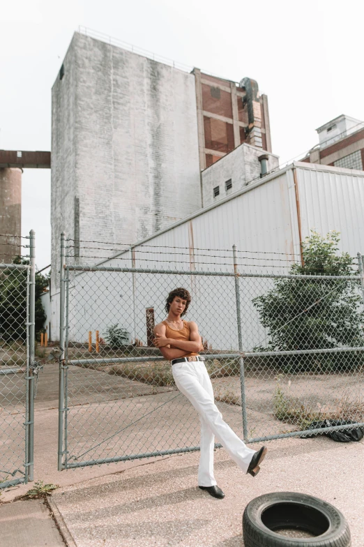 a man leaning on a fence near a tire