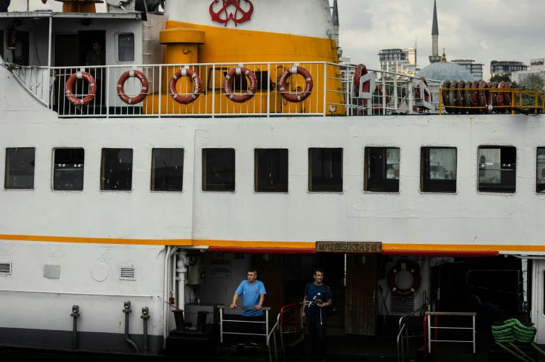 two men standing in the doorway of a big boat