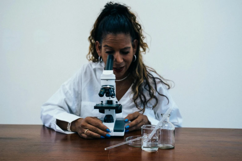 the woman is looking through her microscope