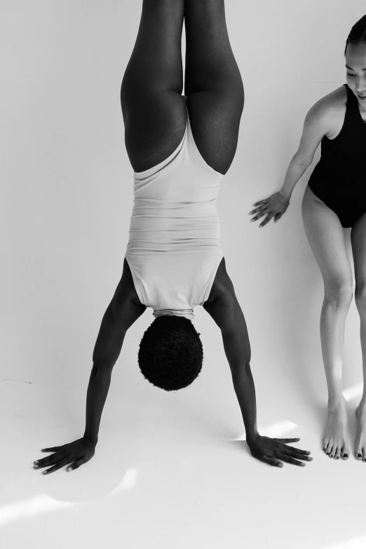 two women in bathing suits are doing gymnastics