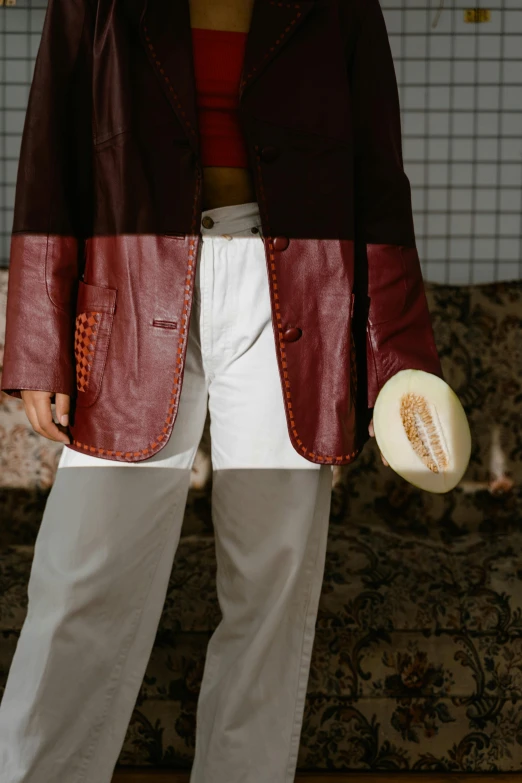 a woman in a red shirt and pants with white pants holding a frisbee