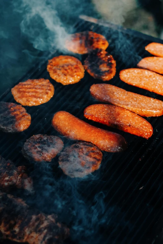 cooking hamburgers and sweet potatoes on a grill