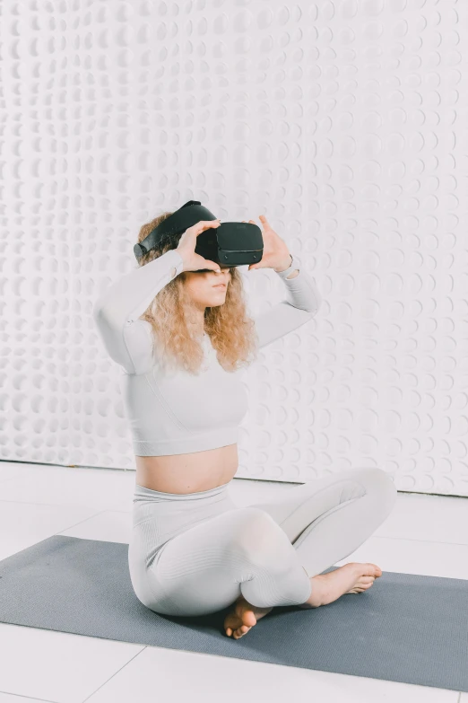 a girl is sitting on the ground while holding a cup