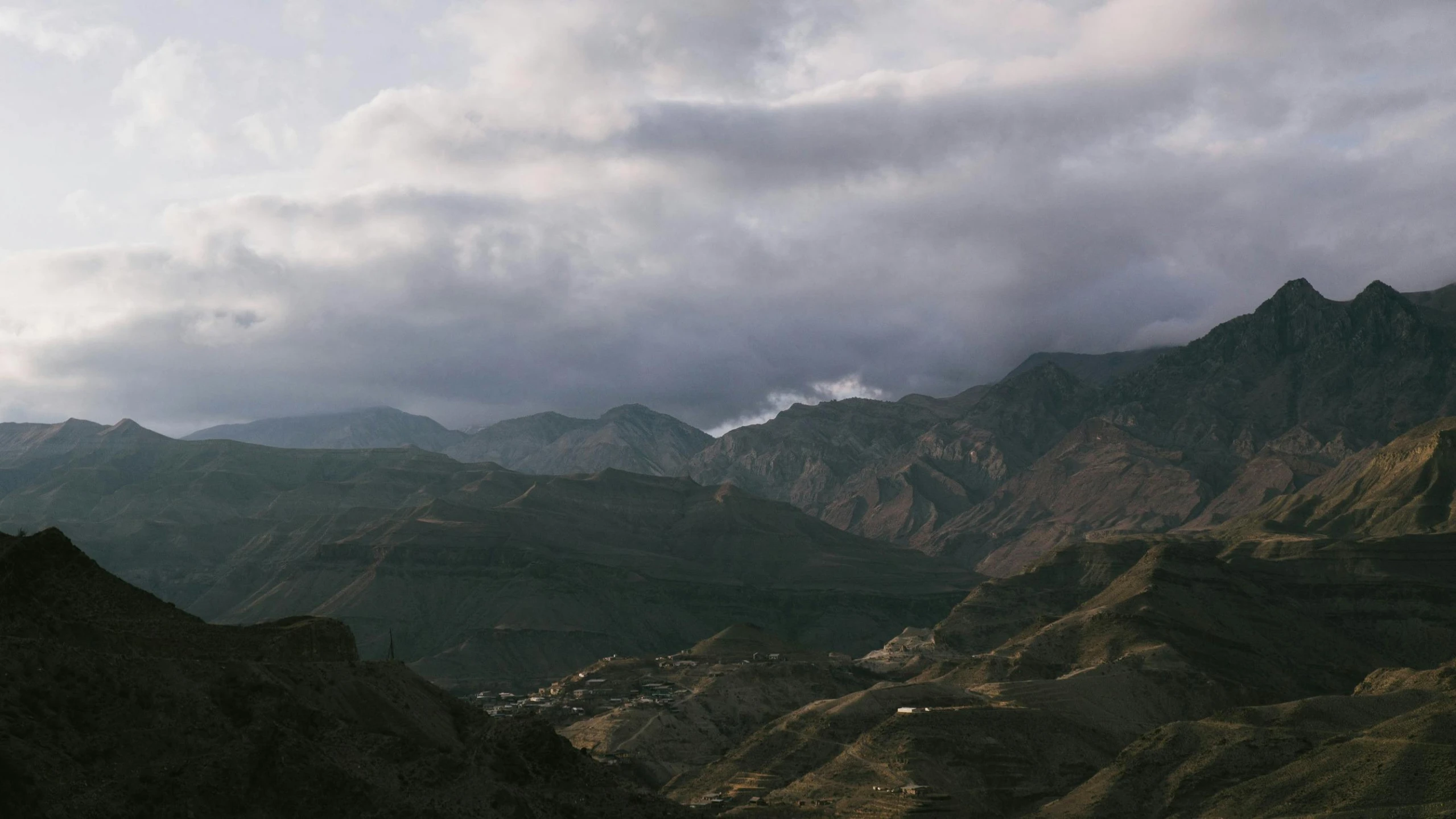 a large mountain range surrounded by lush green trees