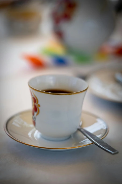 a white tea cup on a saucer with a spoon