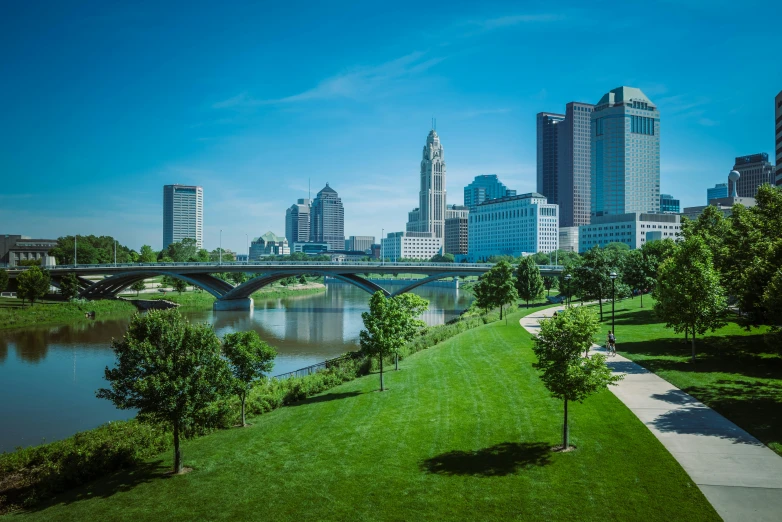 a view of a beautiful green city across the river