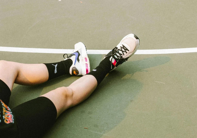 a man sitting on the court while playing tennis