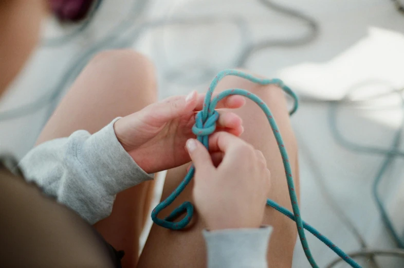 someone is tying a light bulb to a string