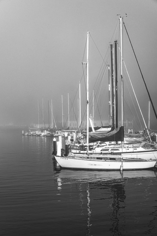 a sailboat is in the water on a foggy day