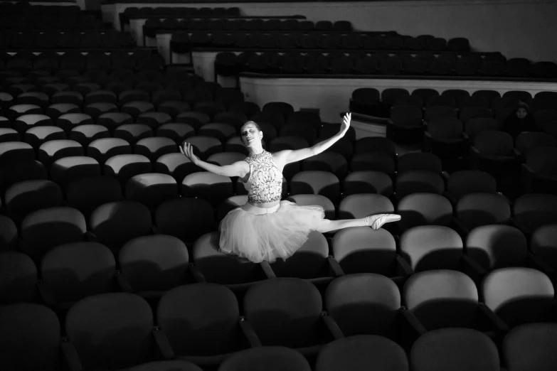 the ballerina is practicing ballet in the auditorium