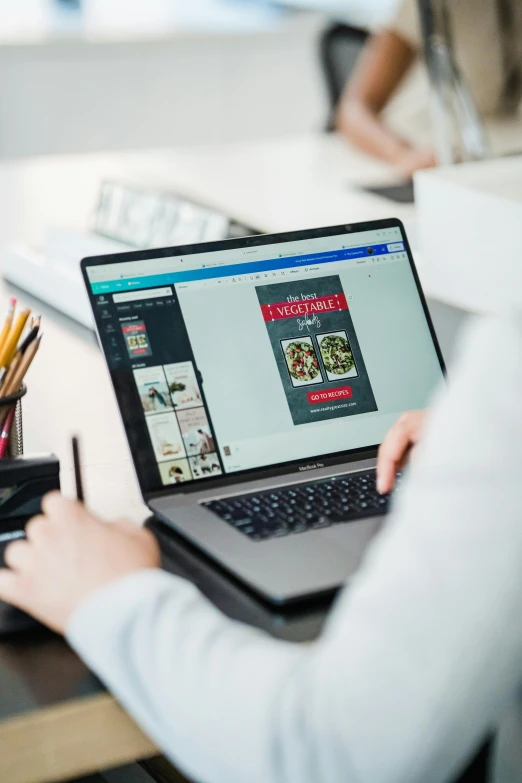 woman in white sweater holding onto black laptop computer