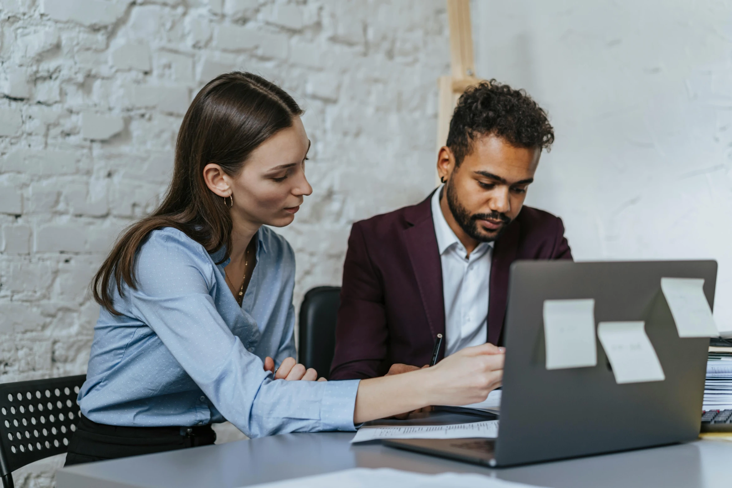 a man and woman working on their laptop