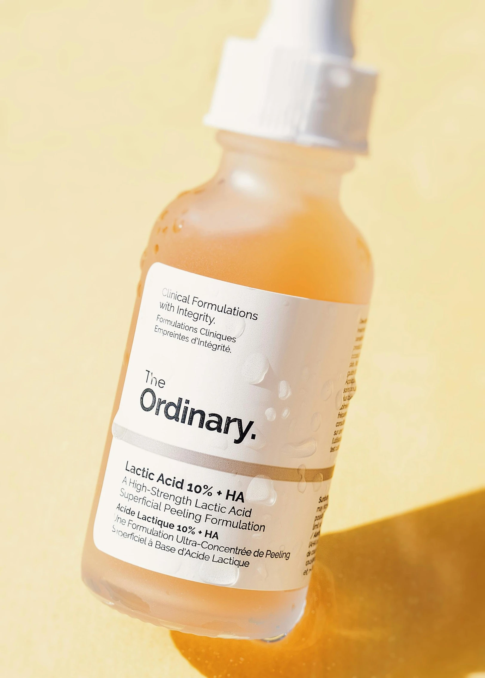 a bottle of ordinary skin care product is sitting on a yellow surface