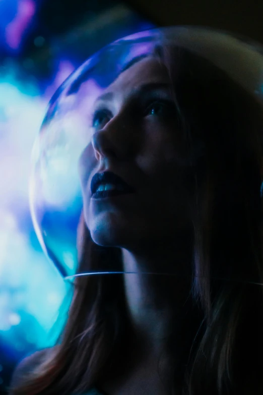 a girl looking at an image in the glass ball