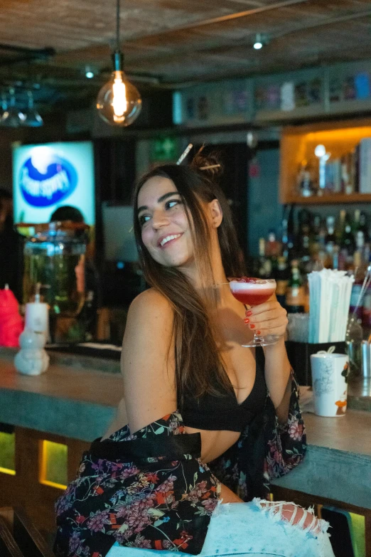 a woman standing in front of a bar with a large paper bag on her shoulder