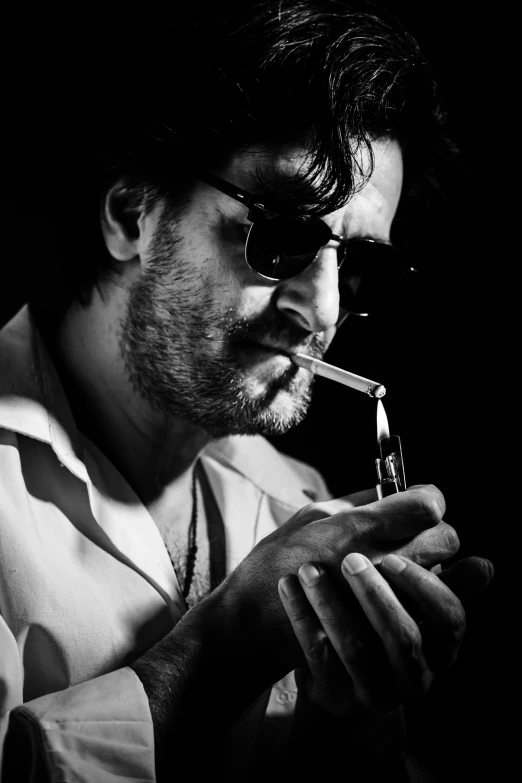 a man with glasses smoking a pipe in the dark