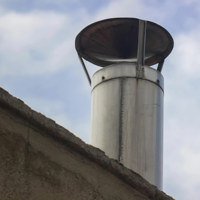 an old, dirty metal object sticking out of the side of a building