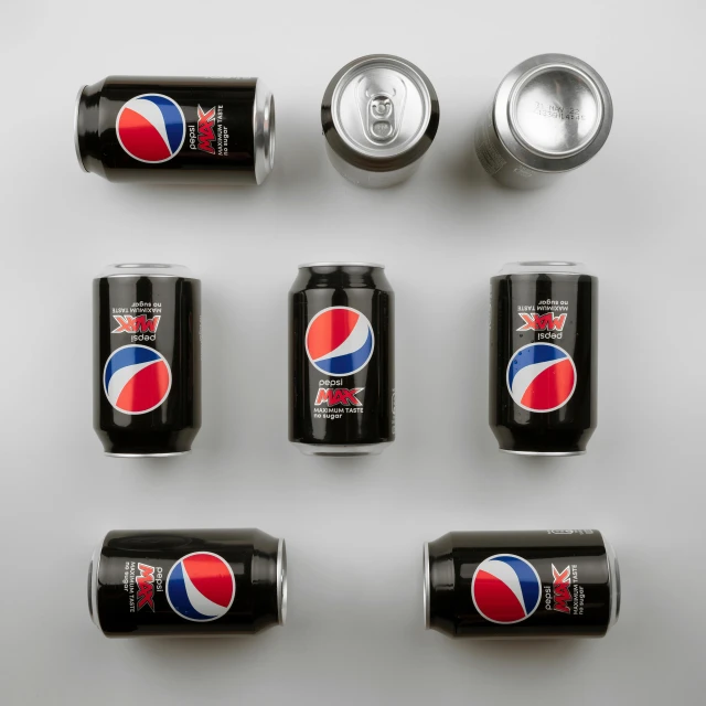 six cans of soda and some cans are shown together