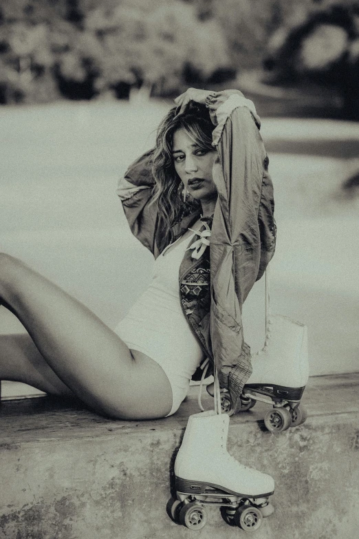 woman leaning down on her skateboard while sitting on the ground