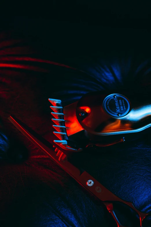 a red scissor sits next to some dark tools