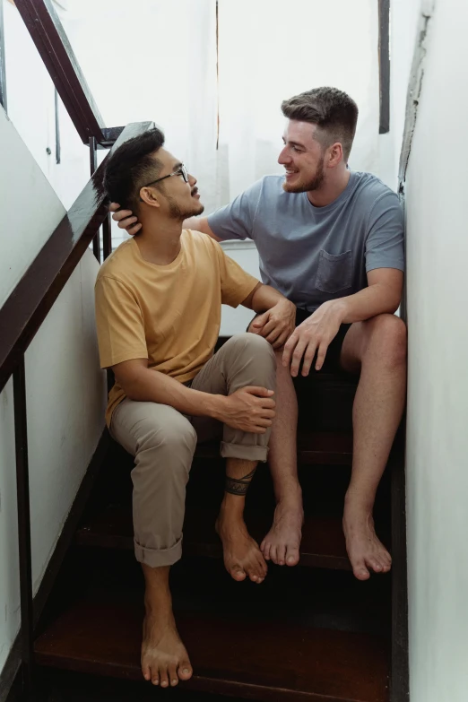 an image of a man sitting on a stair case talking to another man