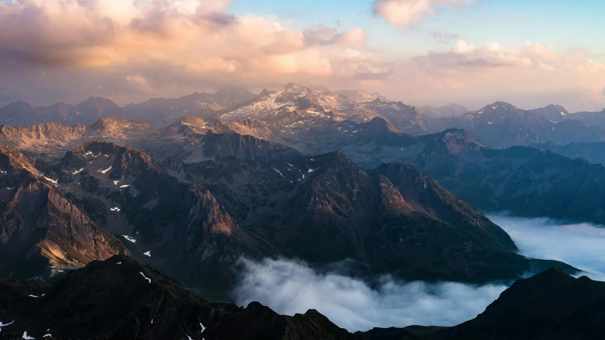 a large mountain with some clouds around it