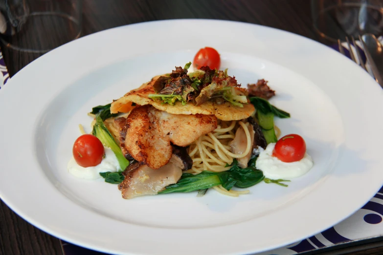 food on a white plate with red cherry tomatoes