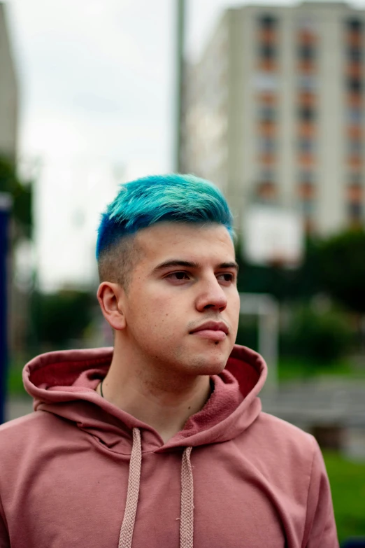 a young man with blue hair looking at the camera