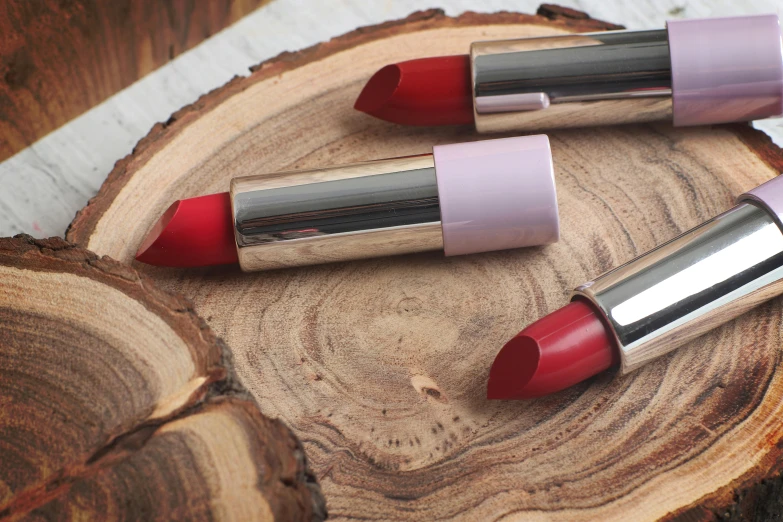 three lip lacries of various red - tinted lipstick