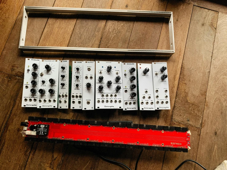 five controls attached to a red band sitting on a wood floor