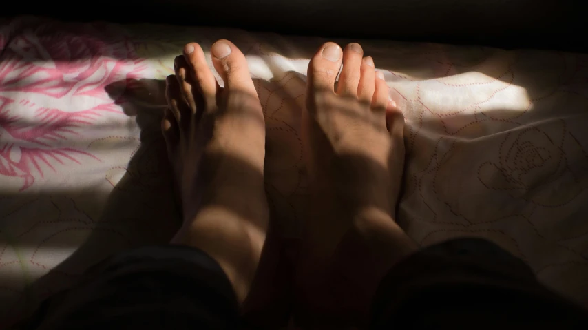 a person has their feet off the bed