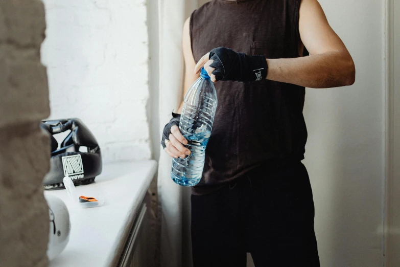 a man wearing a wrist band and holding up his bottle of water